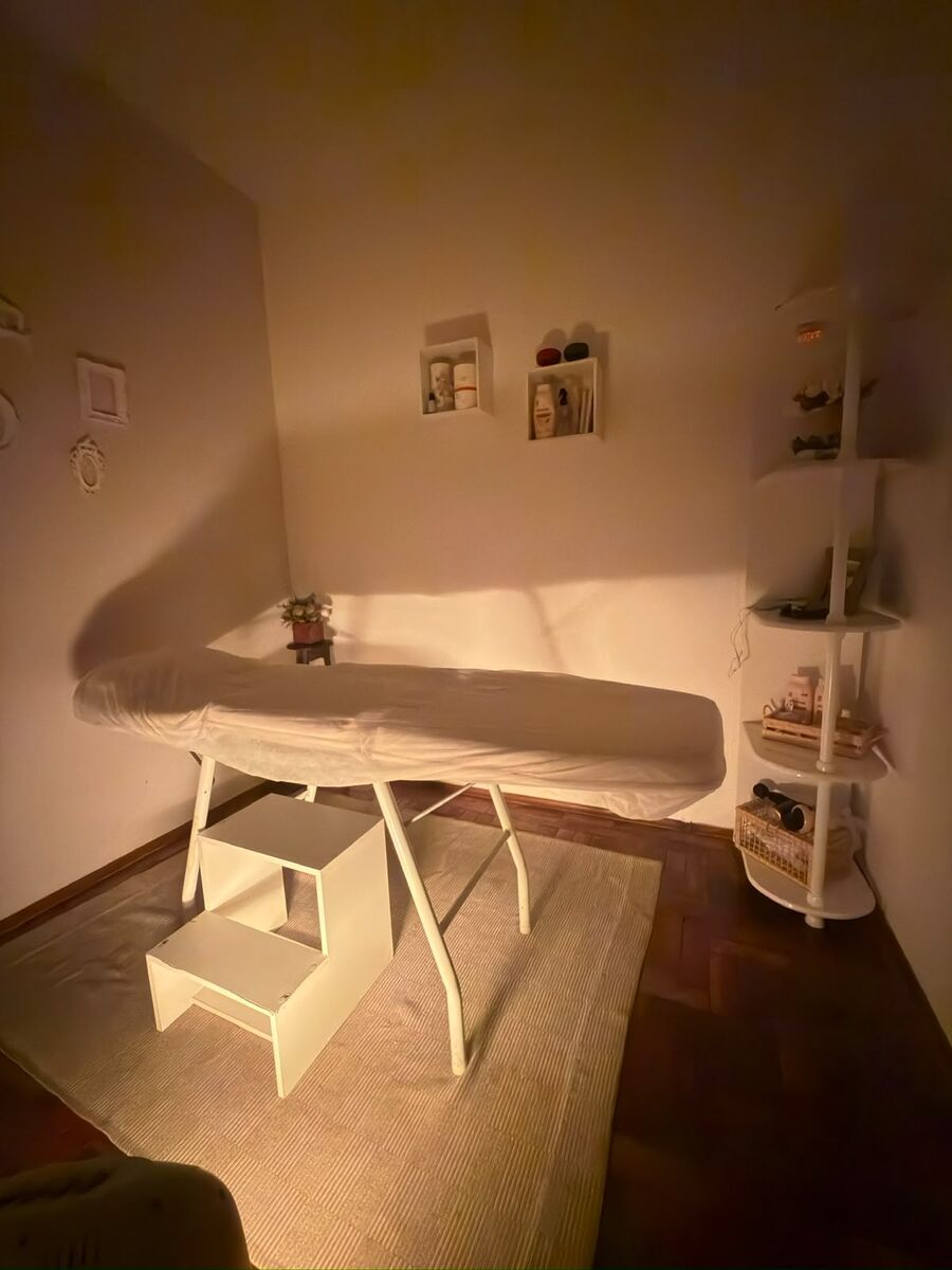 Sala de atendimento com maca, iluminação suave e prateleiras